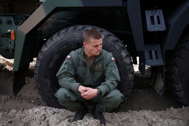  Polish soldier squats ahead of a press conference, a week before the National Army Day Parade, at Wesola military base in Warsaw, Poland, August 8, 2023. (photo credit: REUTERS)