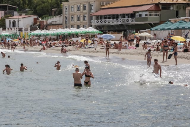  People relax at a Black Sea beach that was reopened after being closed down last year following sea mines laid around the ports of Odesa and Mykolaiv by Russia and Ukraine, amid Russia's attack on Ukraine, in Odesa, Ukraine August 10, 2023. (photo credit: REUTERS/Serhii Smolientsev)