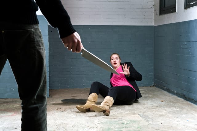  Murderer, holding a knife, face to face with a terrified woman in a basement (illustrative). (photo credit: INGIMAGE)