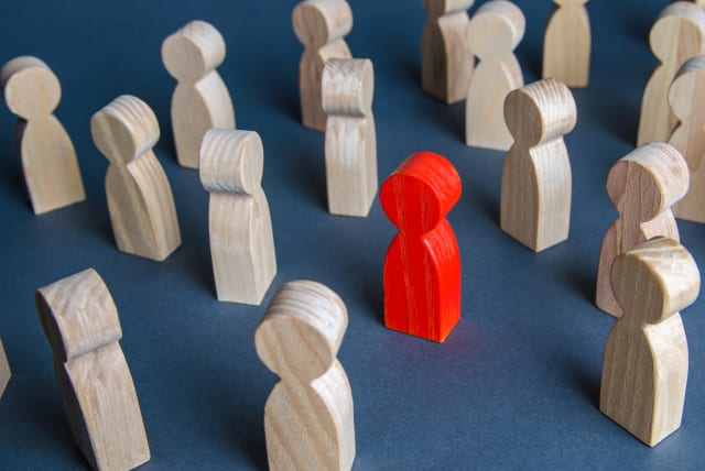  Red figurine of a man in a crowd of people (illustrative) (photo credit: INGIMAGE)