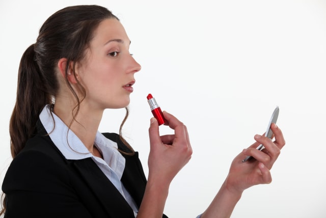 Woman applying lipstick (illustrative). (photo credit: INGIMAGE)