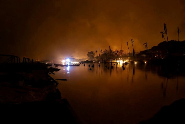  lames are seen near Lahaina as wildfires driven by high winds destroy a large part of the historic town of Lahaina, Hawaii, US, August 9, 2023. (photo credit: Dustin Johnson/Handout via REUTERS)