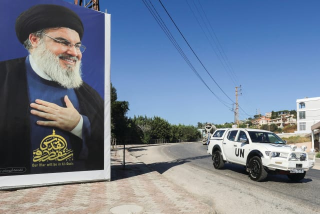  A UNIFIL VEHICLE drives near a picture showing Hezbollah leader Hassan Nasrallah, in Adaisseh village, near the Lebanese-Israeli border, last month. (photo credit: AZIZ TAHER/REUTERS)