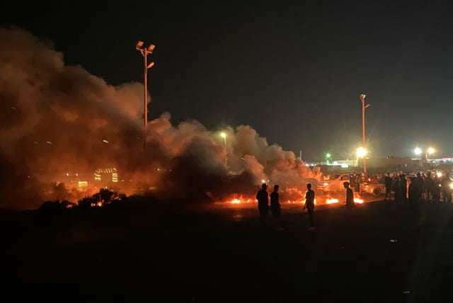 Demonstrators burn tires in protest against the meeting which was held last week in Italy between foreign affairs ministers of Libya and Israel, in Tripoli, Libya, August 27, 2023 (photo credit: REUTERS/Hani Amara)