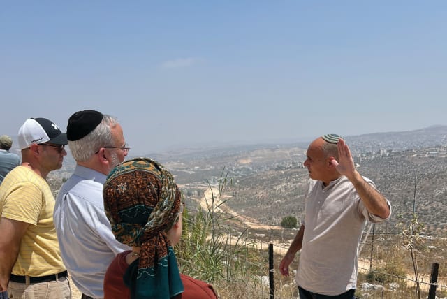  THE WRITER leads an AFJS group on a tour in Samaria, earlier this month. The Huwara bypass road under construction is in the background.  (photo credit: JOSH HASTEN)