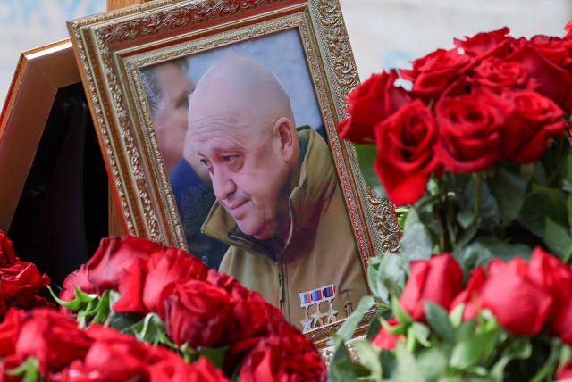  A view shows a framed photo of Russian mercenary chief Yevgeny Prigozhin at his grave at the Porokhovskoye cemetery in Saint Petersburg, Russia, August 30, 2023.  (photo credit: REUTERS/STRINGER)