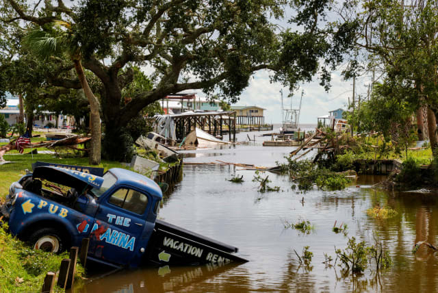  A view of a vehicle partially submerged in a canal after the arrival of Hurricane Idalia in Horseshoe Beach, Florida, U.S., August 30, 2023. (photo credit: REUTERS/Cheney Orr)