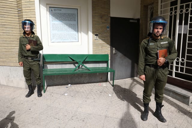 Police officers stand guard holding the Koran in their hands outside the Swedish Embassy, during a protest against a man who burned a copy of the book outside a mosque in the Swedish capital Stockholm, in Tehran, Iran July 3, 2023. (photo credit: Majid Asgaripour/West Asia News Agency/Reuters)