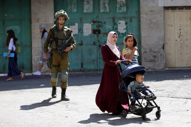  Israeli security forces guard as Jews (unseen) tour in the West Bank city of Hebron, during the Jewish holiday of Sukkot, September 22, 2021. (photo credit: WISAM HASHLAMOUN/FLASH90)
