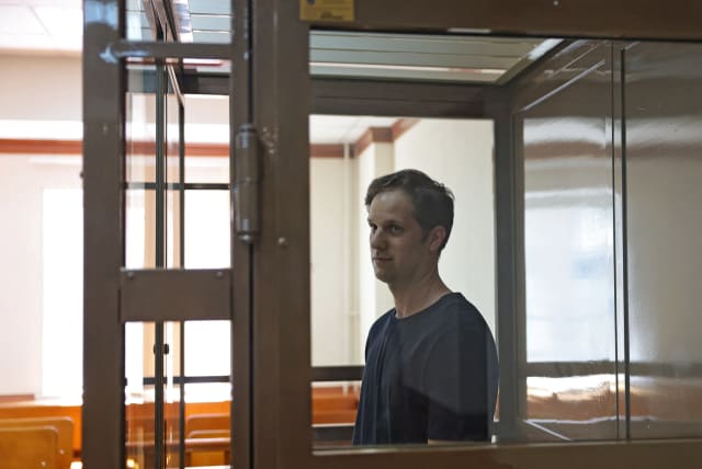  Wall Street Journal reporter Evan Gershkovich, who was arrested in March while on a reporting trip and accused of espionage, stands behind a glass wall of an enclosure for defendants before a court hearing to consider an appeal against his detention, in Moscow, Russia June 22, 2023. (photo credit: REUTERS/EVGENIA NOVOZHENINA)