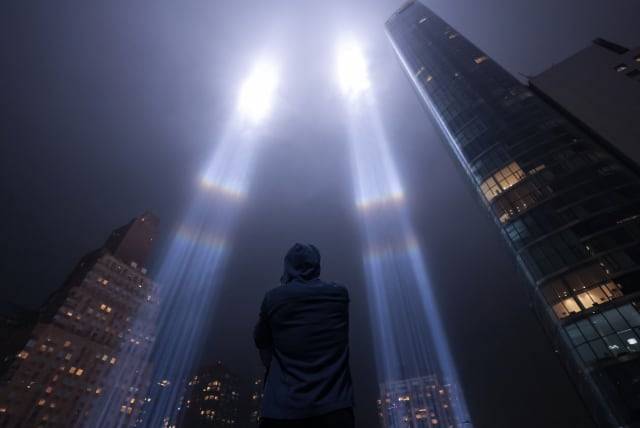 A person looks toward the Tribute in Light for the remembrance of the 21st anniversary of the September 11, 2001 attacks in Manhattan, New York City, U.S., September 11, 2022.  (photo credit: Andrew Kelly/Reuters)