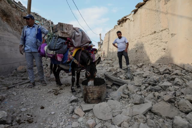  A man stands next to a donkey that carries his belongings days after the deadly earthquake, in the village of Adouz, Morocco September 12, 2023. (photo credit: REUTERS/EMILIE MADI)