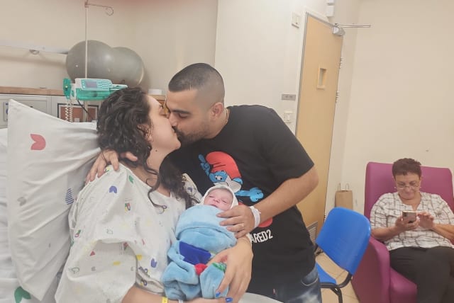  The Sarusi family is seen holding their newborn, the first Israeli child born in the Jewish New Year 5784 (photo credit: COURTESY OF WOLFSON MEDICAL CENTER)