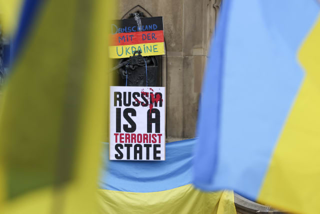  A sticker that reads "Russia is a terrorist state" is attached to a flag of Ukraine during a gathering to protest against a pro-Russia demonstration amid the Russian invasion of Ukraine in Frankfurt, Germany, September 18, 2022 (photo credit: REUTERS)