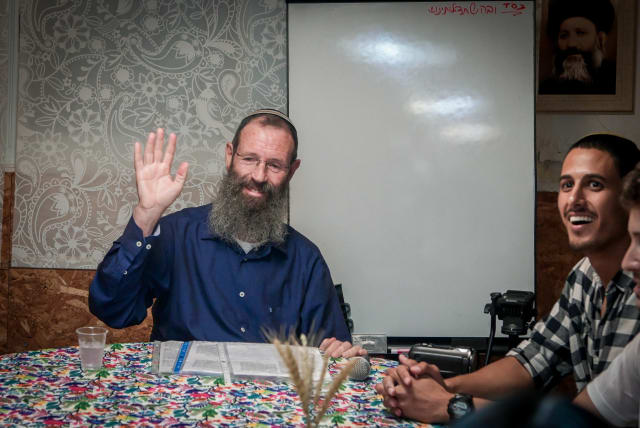  Rabbi Yigal Levinstein delivers a lesson while activists protest against him outside an apartment building in Tel Aviv, on September 19, 2023. (photo credit: AVSHALOM SASSONI/FLASH90)