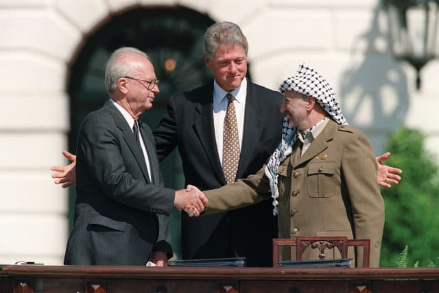  THE FAMOUS handshake: Prime minister Yitzhak Rabin seals the deal with PLO leader Yasser Arafat as US president Bill Clinton admires his handiwork, at the White House upon the signing of the Oslo Accords, Sept. 13, 1993.  (photo credit: J. David Ake/AFP via Getty Images)