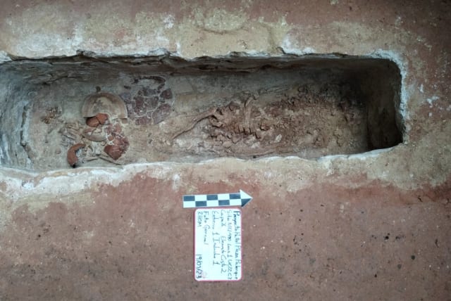 The remains of a human burial, unearthed by Mexican archaeologists during salvage work carried out in Palenque in tandem with building the rail project known as the Maya Train, are seen in this undated Handout photo received from Mexico's National Institute of Anthropology and History (INAH) on Sept (photo credit: INAH/Handout via REUTERS)