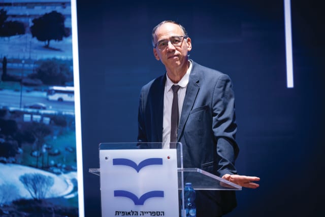  SHAI NITZAN, rector of the National Library of Israel, stands in the library’s new building, in Jerusalem, with the logo which shows an open white book with blue edges. (photo credit: YONATAN SINDEL/FLASH90)