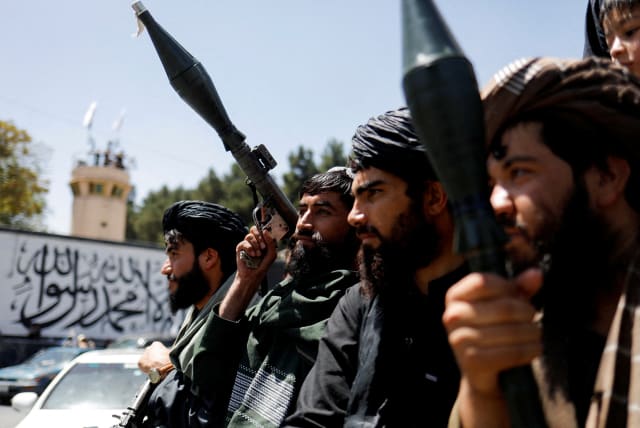  Taliban soldiers celebrate on the second anniversary of the fall of Kabul on a street near the US embassy in Kabul, Afghanistan, August 15, 2023 (photo credit:  REUTERS/ALI KHARA)