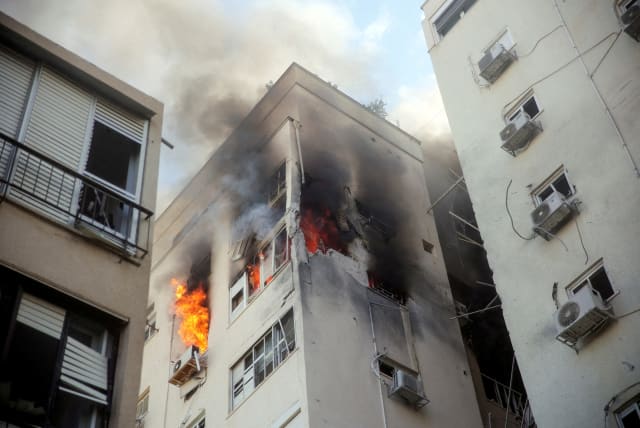  A building is ablaze following rocket attacks from the Gaza Strip, in Tel Aviv, Israel October 7, 2023.  (photo credit: REUTERS/ITAI RON)
