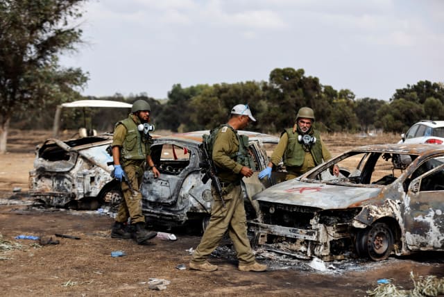  Israeli soldiers inspect the burnt cars of festival-goers at the site of an attack on the Nova Festival by Hamas gunmen from Gaza, near Israel's border with the Gaza Strip, in southern Israel, October 13, 2023.  (photo credit: REUTERS/AMIR COHEN)
