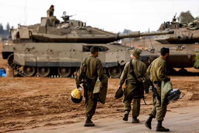  Israeli soldiers walk past Israeli tanks near Israel's border with the Gaza Strip, in southern Israel October 15, 2023. (photo credit: REUTERS/AMIR COHEN)