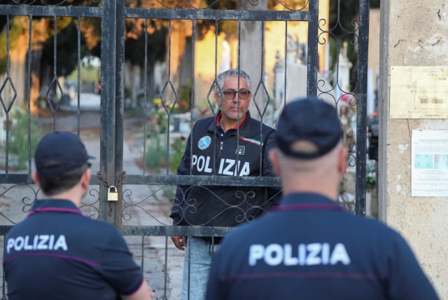 Police stand outside the cemetery, where late mafia boss Matteo Messina Denaro is buried, in the Sicilian town of Castelvetrano, Italy, September 27, 2023. (photo credit: REUTERS/Igor Petyx)