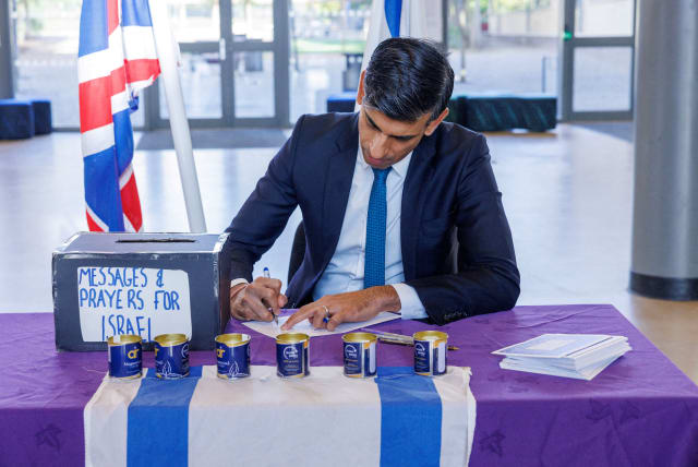 British Prime Minister Rishi Sunak signs messages and prayers for Israel at a Jewish school in London, Britain October 16, 2023 (photo credit: Jonathan Buckmaster/Pool via REUTERS)