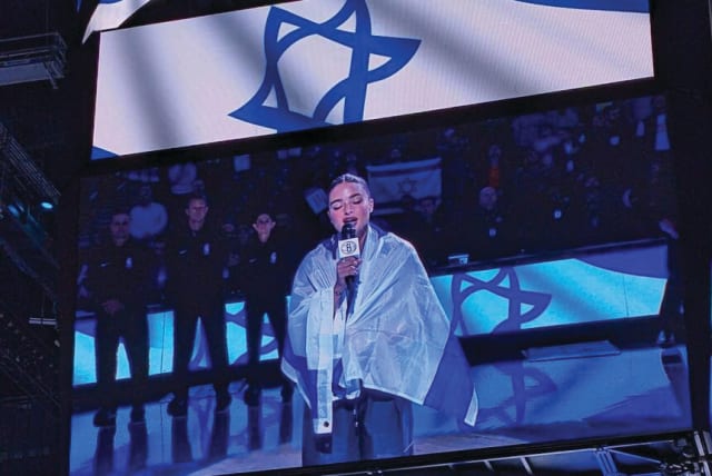  DRAPED IN THE Israeli flag, Noa Kirel performs ‘Hatikvah’ at Barclays Center before the NBA’s Brooklyn Nets played Maccabi Ra’anana last week. (photo credit: Am Israel Chai)