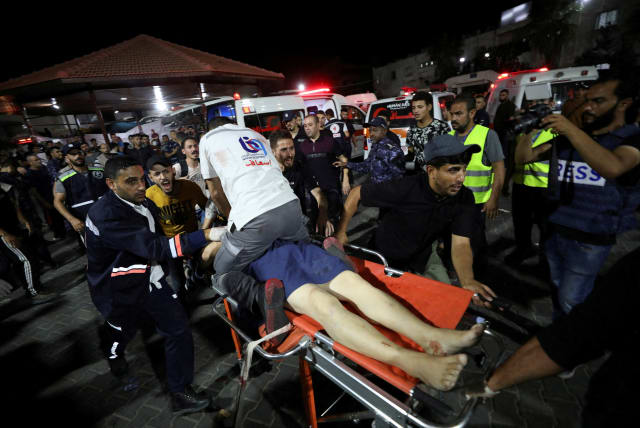 People are assisted at Shifa Hospital after many Palestinians were killed in a blast at Al-Ahli hospital in Gaza on October 18, 2023. (photo credit: REUTERS/MOHAMMED AL-MASRI)