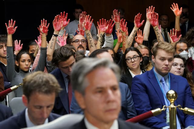  Anti-war protesters raise their "bloody" hands behind US Secretary of State Antony Blinken during a Senate Appropriations Committee hearing on President Biden's $106b. national security supplemental funding request to support Israel and Ukriane, on Capitol Hill in Washington, US, October 31, 2023. (photo credit: KEVIN LAMARQUE/REUTERS)