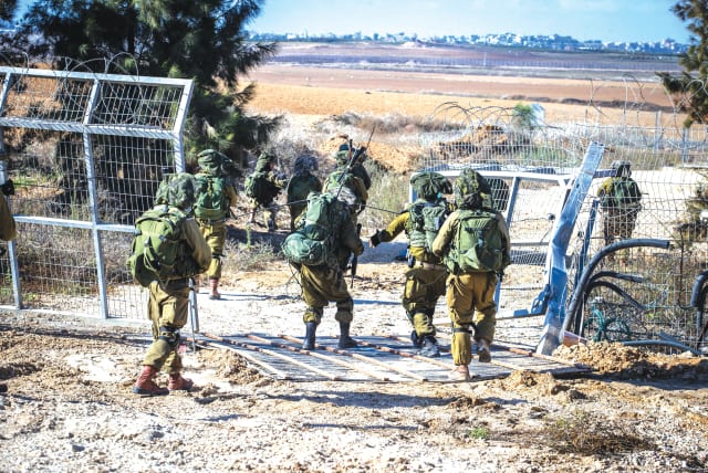  IDF SOLDIERS take up a position at the fence of Kibbutz Kfar Aza, near the Israel-Gaza border. (photo credit: OREN BEN HAKOON/FLASH90)