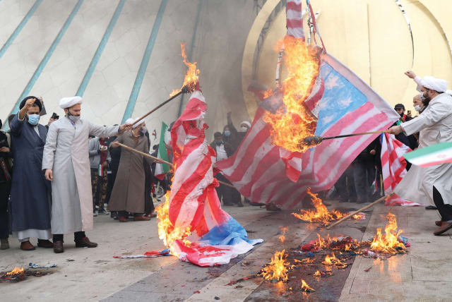  IRANIAN CLERICS set fire to American flags on February 11, 2022, the 43rd anniversary of the Islamic Revolution, in Tehran.  (photo credit: Majid Asgaripour/West Asia News Agency/Reuters)