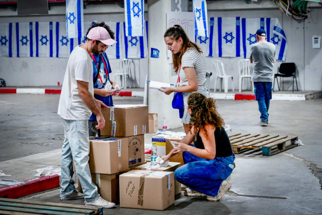  Israeli citizens pack donations of food and other necessities for the Israeli soldiers and citizens in the south, in Tel Aviv, October 15, 2023. (photo credit: AVSHALOM SASSONI/FLASH90)