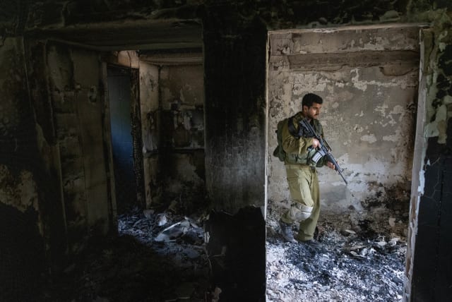  Israeli soldier around the destruction caused by Hamas terrorists in Kibbutz Nir Oz on October 7, 2023, near the Israeli-Gaza border, in southern Israel, October 30, 2023. (photo credit: Chaim Goldberg/Flash90)