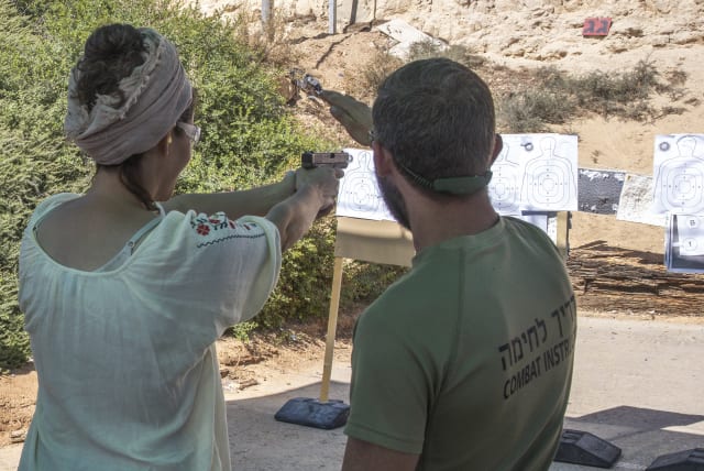  A woman is seen using a gun at Caliber 3's shooting range.  (photo credit: MARC ISRAEL SELLEM/THE JERUSALEM POST)