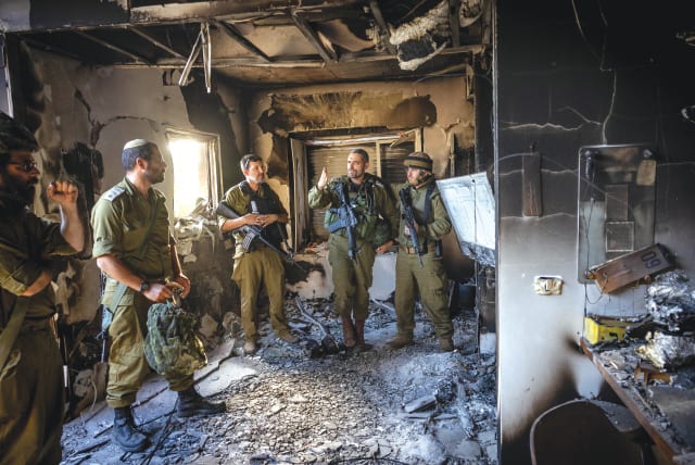  Israeli soldiers stand amid the destruction at Kibbutz Be'eri. The State of Israel bowed its head and mourned, but it also rose from the carnage to fight back, says the writer. (photo credit: YONATAN SINDEL/FLASH90)