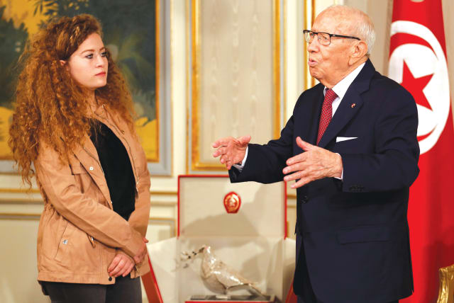  Then-Tunisian President Beji Caid Essebi honors Ahed Tamimi in Tunis, 2018. Now, at last, she has finally removed her mask, say the writers. She posted on Instagram: 'What Hitler did to you was a joke.' (photo credit: ZOUBEIR SOUISSI / REUTERS)