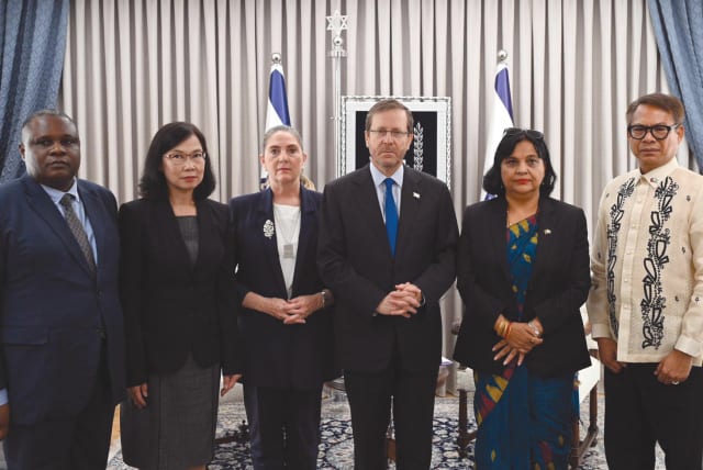  President Isaac Herzog and his wife, Michal, flanked by ambassadors of countries whose citizens are among the hostages in Hamas captivity; (from left) Alex Gabriel Kalua of Tanzania, Pannabha Chandraramya of Thailand, Kanta Rizal of Nepal, and Pedro Laylo of Philippines. (photo credit: HAIM ZACH/GPO)