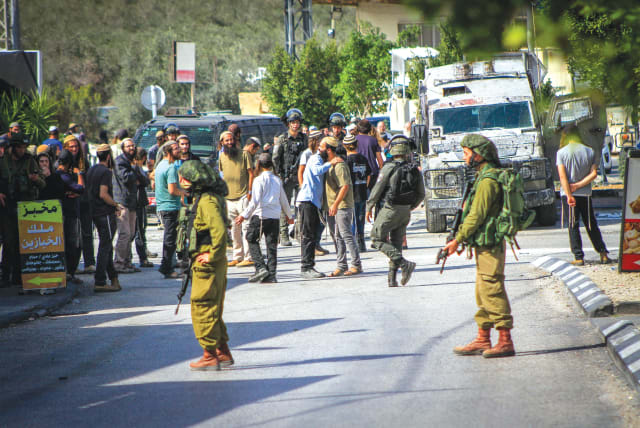  IDF SOLDIERS prevent settlers from entering the village of Deir Sharaf, west of Nablus, in response to a shooting attack last Thursday. (photo credit: NASSER ISHTAYEH/FLASH90)
