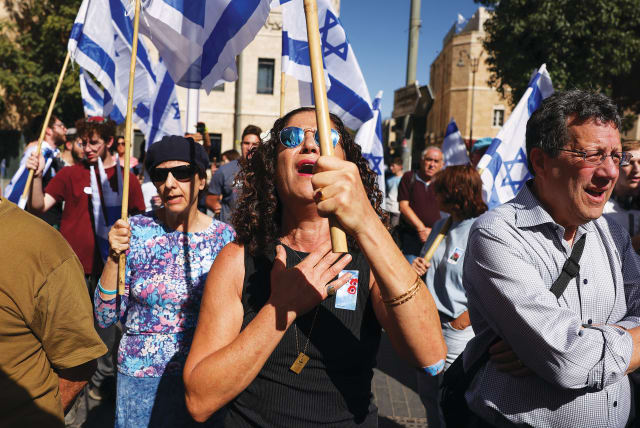  PEOPLE HOLD Israeli flags during a ceremony in early November in Jerusalem to mark the one-month anniversary of the October 7 Hamas massacre. (photo credit: RONEN ZVULUN/REUTERS)