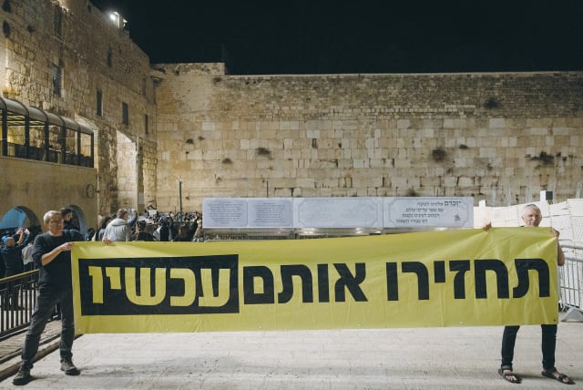  A SIGN reads ‘Return them now,’ at a ceremony and prayer at the Western Wall last week for those abducted by Hamas terrorists during the massacre.  (photo credit: Chaim Goldberg/Flash90)