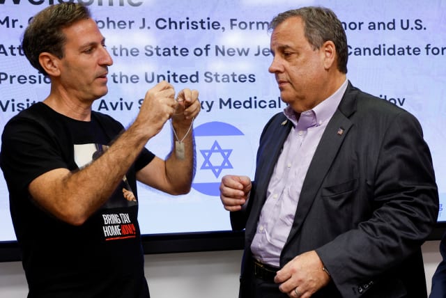  Ruby Chen, the American father of a hostage held by Hamas shows a dog tag with the words "Bring them home" on it to the former New Jersey Governor Chris Christie, at Sourasky Medical Center (Ichilov) in Tel Aviv, Israel November 12, 2023 (photo credit: REUTERS/AMIR COHEN)