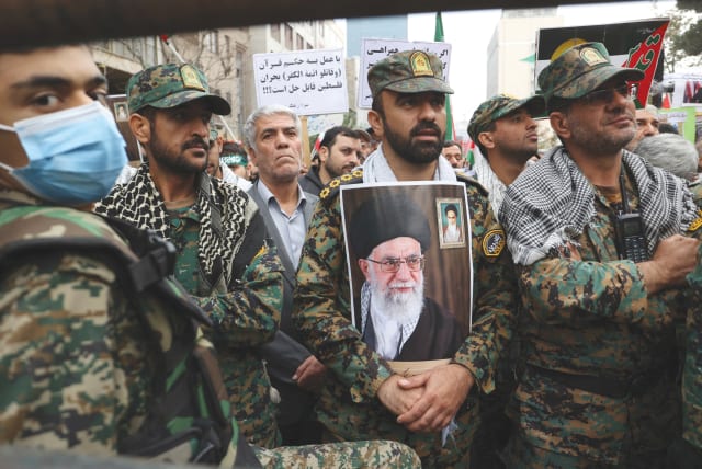  A member of the Iranian police holds a picture of Iran's Supreme Leader Ayatollah Ali Khamenei on the 44th anniversary of the US expulsion from Iran, earlier this month, in Tehran. (photo credit: WEST ASIA NEWS AGENCY/REUTERS)