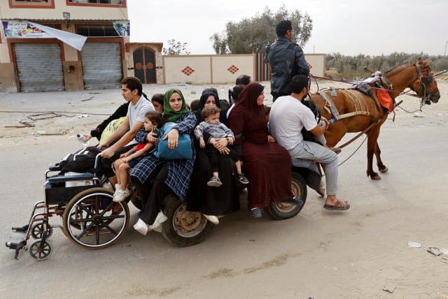  Palestinians fleeing north Gaza ride a horse-drawn cart as they move southward, as Israeli tanks roll deeper into the enclave, amid the ongoing conflict between Israel and Hamas, in the central Gaza Strip November 12, 2023. (photo credit: IBRAHEEM ABU MUSTAFA/REUTERS)