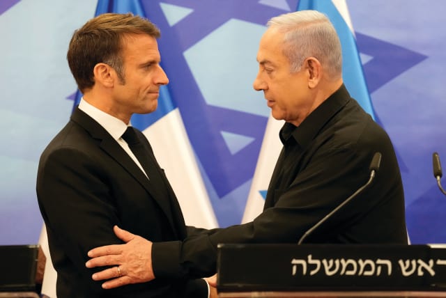  Prime Minister Benjamin Netanyahu and French President Emmanuel Macron embrace at a joint news conference in Jerusalem last month. Macron called for the anti-ISIS coalition to regroup against Hamas. (photo credit: CHRISTOPHE ENA/REUTERS)