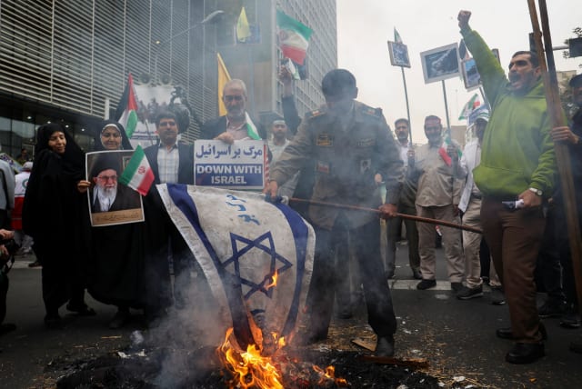  An Iranian man burns an Israeli flag during the 44th anniversary of the US expulsion from Iran, in Tehran, Iran November 4, 2023 (photo credit: MAJID ASGARIPOUR/WANA (WEST ASIA NEWS AGENCY) VIA REUTERS)