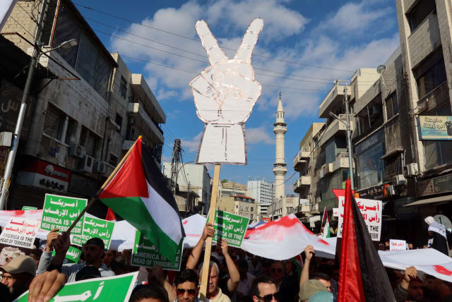  Demonstrators carry banners and flags during a protest in support of Palestinians in Gaza, amid the ongoing conflict between Israel and the Palestinian Islamist group Hamas, in Amman, Jordan November 17, 2023.  (photo credit: REUTERS/JEHAD SHELBAK)
