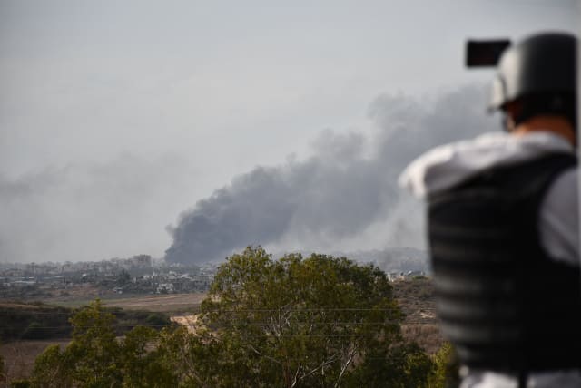  A journalist photographs fighting in Gaza from Sderot on November 22, 2023. (photo credit: SETH J. FRANTZMAN)