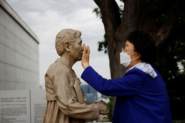  Former South Korean "comfort woman" Lee Yong-soo looks at a statue symbolising "comfort women" at the Seoul Comfort Women Memorial in Seoul, South Korea, June 29, 2021 (photo credit: REUTERS/KIM HONG-JI)